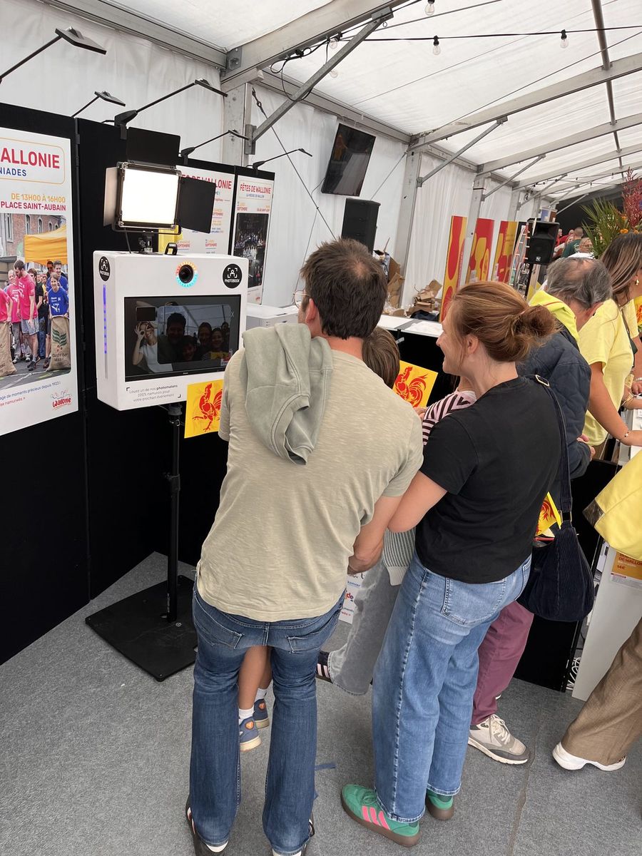 Des visiteurs découvrent leurs photos sur l'écran du photomaton Photoboox
